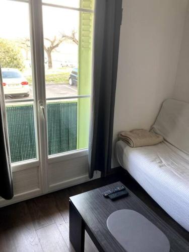 une chambre avec un lit, une table et une fenêtre dans l'établissement Appartement entier au RDC, à Salon-de-Provence