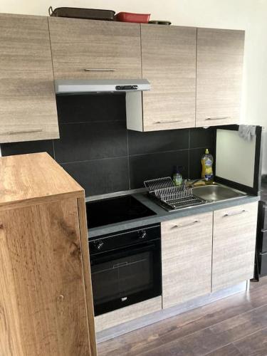 une cuisine avec une cuisinière et un évier dans l'établissement Appartement entier au RDC, à Salon-de-Provence