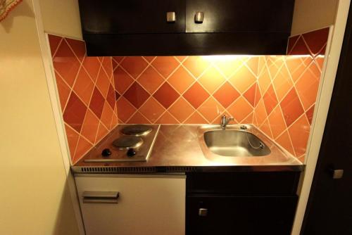 une petite cuisine avec un évier et une cuisinière dans l'établissement Résidence Roche Blanche - A PROXIMITE DES COMMERCES STUDIO POUR 2 PERSONNES MAE-7808, à Val Thorens