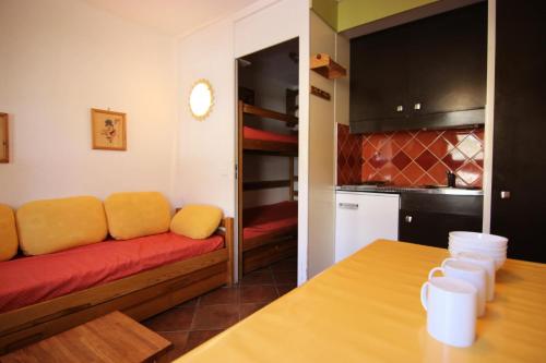 un salon avec un canapé rouge et une cuisine dans l'établissement Résidence Roche Blanche - A PROXIMITE DES COMMERCES STUDIO POUR 2 PERSONNES MAE-7808, à Val Thorens