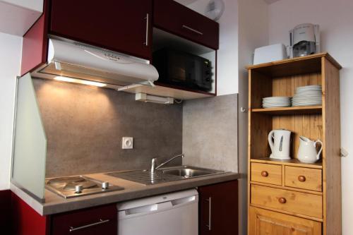 une petite cuisine avec un évier et un micro-ondes dans l'établissement Résidence Vanoise - VAL THORENS STUDIO 2 PERSONNES AU COEUR DE LA STATION ET SKIS AU PIEDS MAE-7806, à Val Thorens
