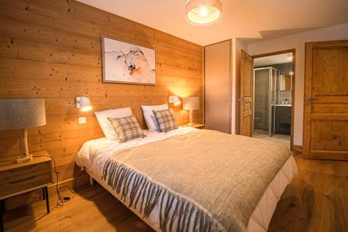 une chambre avec un lit et un mur en bois dans l'établissement Résidence Lumi Batiment B - LUMIB 401 MAE-5941, à Valmorel