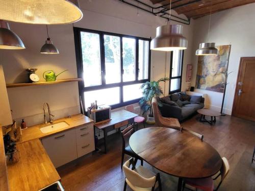 une cuisine et un salon avec une table et un canapé dans l'établissement Magnifique Appartement Proche Centre-ville et Gare, à Montpellier