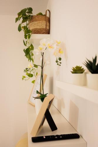 a desk with a keyboard and flowers on it at Pothos Apartment in Terralba