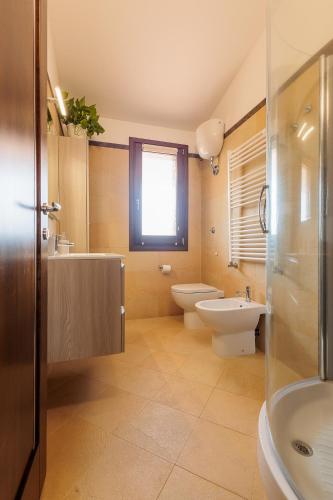 a bathroom with a sink and a toilet and a shower at Pothos Apartment in Terralba