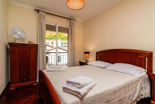 a bedroom with a bed with towels on it at Vila do Conde Nº1 in Ribeira Brava