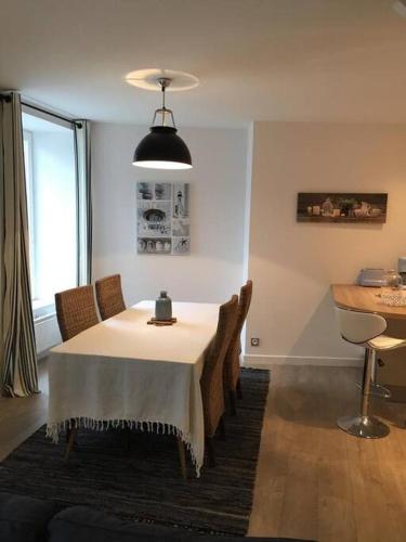 une salle à manger avec une table et des chaises blanches dans l'établissement Duplex, 2 chambres, 75m2 proche Commerces et plage, à Saint-Malo