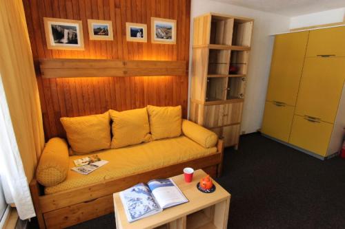 un salon avec un canapé jaune et une table dans l'établissement Résidence Neves - STUDIO AU COEUR DE VAL THORENS MAE-3719, à Val Thorens