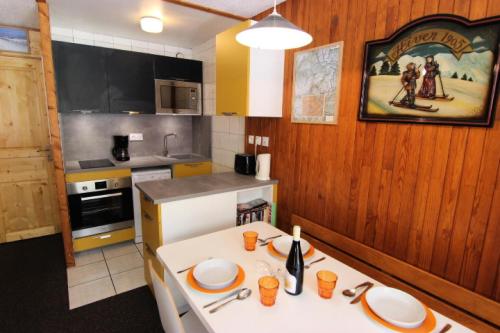 une cuisine avec une table avec des assiettes dessus dans l'établissement Résidence Neves - STUDIO AU COEUR DE VAL THORENS MAE-3719, à Val Thorens