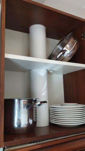 a kitchen shelf with plates and a pot and dishes at B&B La Casa D Ju Nan in Bussi sul Tirino
