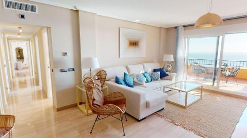a living room with a white couch and blue pillows at Penthouse Bonita Vista al Mar in Águilas
