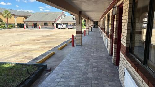 an empty sidewalk next to a brick building at Palace Inn I-45 & Bellfort in Houston