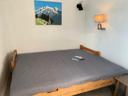 - un lit dans une chambre avec une photo sur le mur dans l'établissement Résidence Vanoise - Appartement coeur station MAE-9714, à Val Thorens