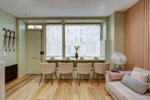 un salon avec une table et des chaises et une fenêtre dans l'établissement Place de la Nation Cozy 2BD Duplex, à Paris