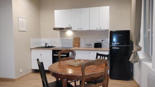 Il comprend une cuisine équipée d'une table et d'un réfrigérateur noir. dans l'établissement Casa Azul, hyper centre - Cours Julien - 4 personnes, à Marseille