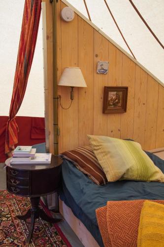a room with a bed and a table in a tent at Kampeerbeleving Dijksehoeve in Nistelrode