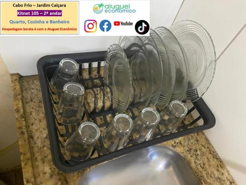 a basket of glasses sitting on top of a sink at Cabo Frio - Jardim Caiçara - Aluguel Econômico in Cabo Frio