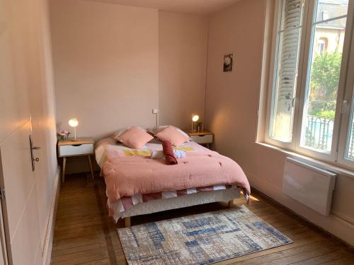 - une chambre avec un lit avec des draps roses et une fenêtre dans l'établissement Centre ville rdc, à Charleville-Mézières