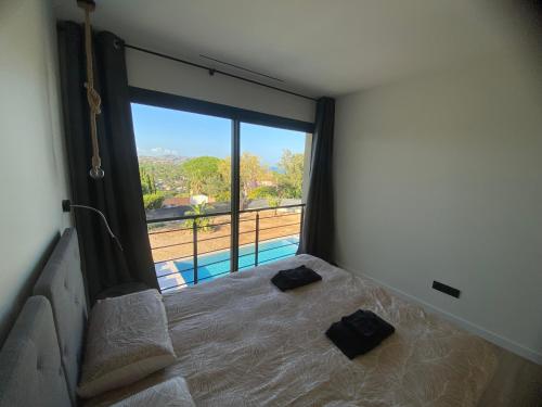 une chambre avec un lit avec vue sur une piscine dans l'établissement Plage de la Nartelle Maison vue mer, à Sainte-Maxime