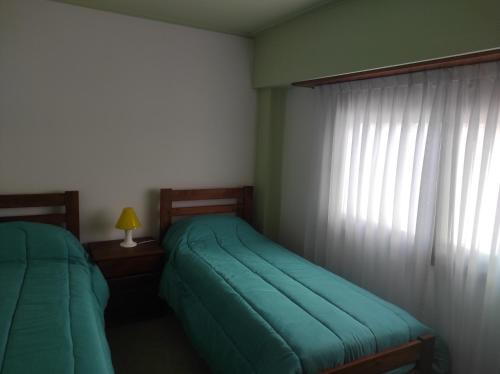 een slaapkamer met 2 aparte bedden en een raam bij EDIFICIO BARROS in Olavarría