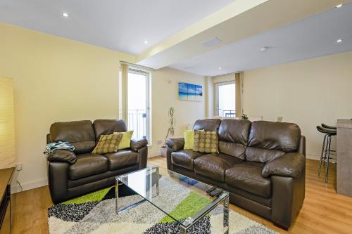 a living room with two leather couches and a table at Bell Street Apartments in Glasgow