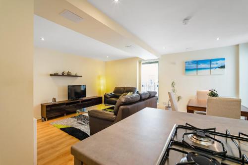 a kitchen and living room with a stove and a couch at Bell Street Apartments in Glasgow