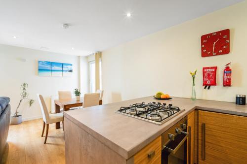 a kitchen with a stove top oven next to a table at Bell Street Apartments in Glasgow