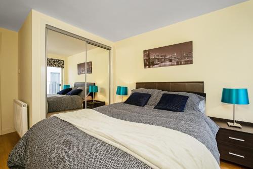 a bedroom with a large bed and a mirror at Bell Street Apartments in Glasgow