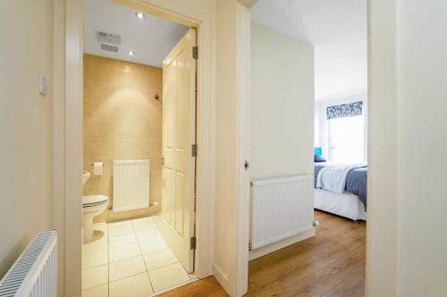 a bathroom with a toilet and a bedroom at Bell Street Apartments in Glasgow