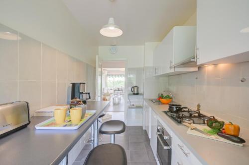 une cuisine avec des armoires blanches et un comptoir dans l'établissement L'Ermitage - Happy Rentals, à Antibes