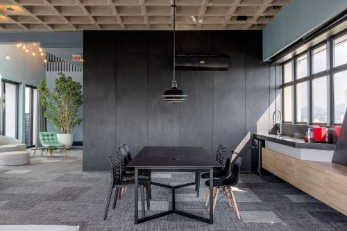 a dining room with a black table and chairs at Loft próximo a Vila Germânica e FURB com vaga. in Blumenau