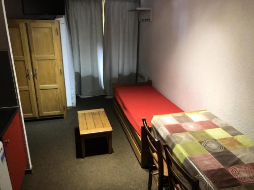 une chambre avec deux lits, une table et une chaise dans l'établissement Résidence Cimes De Caron - Studio pour 4 Personnes MAE-7974, à Val Thorens