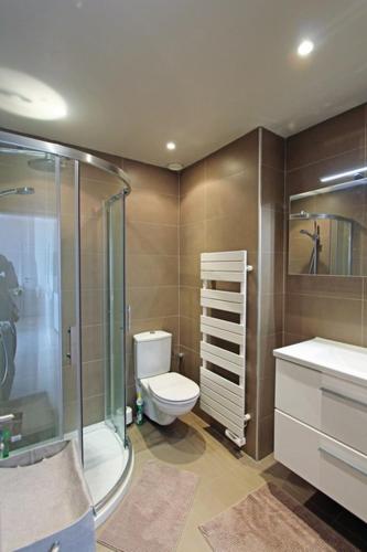 une salle de bain avec toilettes et douche en verre dans l'établissement Bel appartement sur la plage, à Grimaud