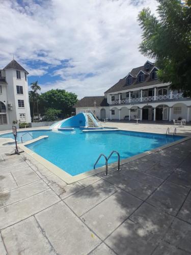 a large swimming pool in front of a building at Contemporary One Bedroom at Sandcastles in Ocho Rios