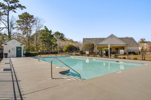 a swimming pool in front of a house at 4 Mi to Brookgreen Gardens Murrells Inlet Condo in Myrtle Beach