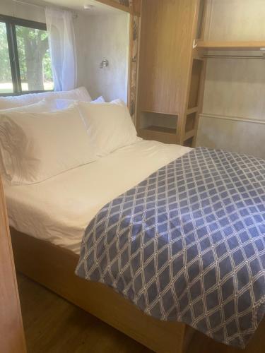 a bed with a blue and white comforter in a room at Farm in Stockbridge