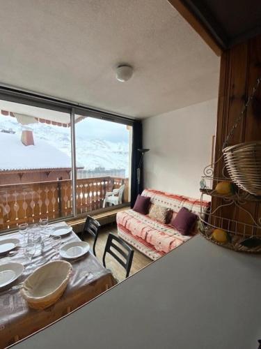 un salon avec une table et une grande fenêtre dans l'établissement Résidence Dome De Polset - Studio pour 3 Personnes MAE-9204, à Val Thorens
