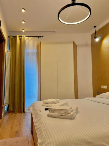 una camera da letto con un letto con asciugamani sopra di Blancris Boutique a Braşov