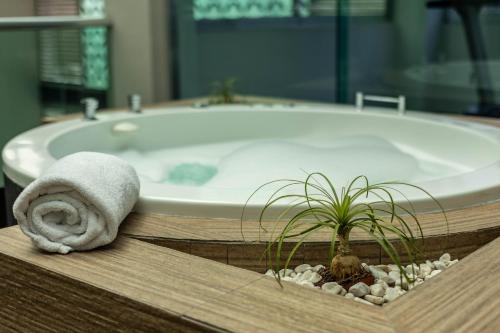 a bath tub with a towel and a potted plant at JTowers in Mexico City