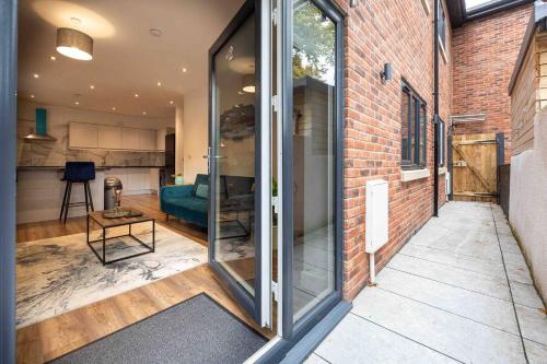 a glass door leading into a room with a brick wall at Vibrant 2br Apartment In Chorlton, Free Parking in Manchester