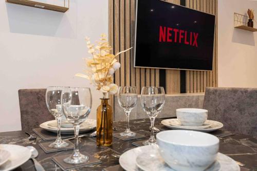 a table with plates and wine glasses on it at Vibrant 2br Apartment In Chorlton, Free Parking in Manchester