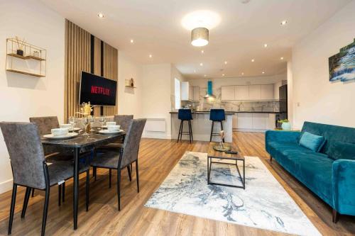 a living room with a table and a blue couch at Vibrant 2br Apartment In Chorlton, Free Parking in Manchester