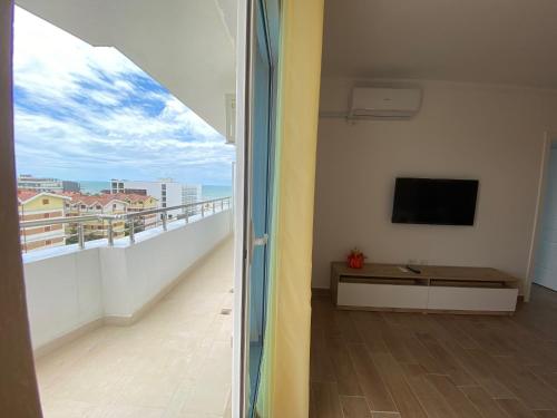 a room with a balcony with a flat screen tv at Best Summer Apartment in Golem