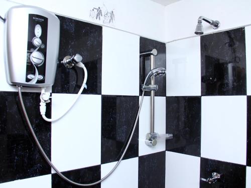 un bagno con doccia e piastrelle bianche e nere di Sethun House a Mirissa