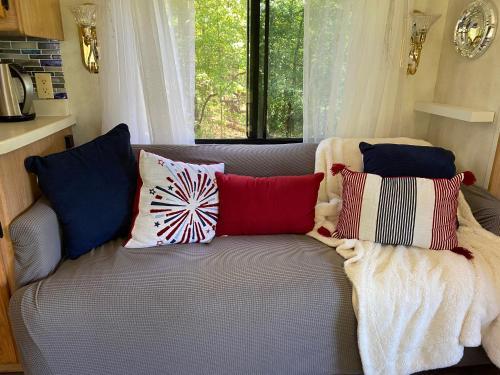 a couch with pillows on it in front of a window at Stinnett Family Farm in Stockbridge