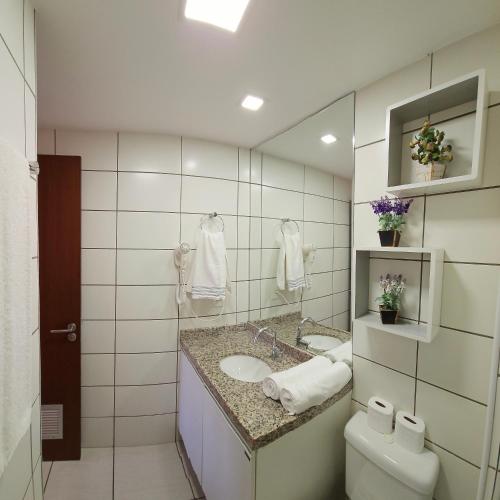 a bathroom with a sink and a toilet and a mirror at Beach Class by Solemar in Fortaleza
