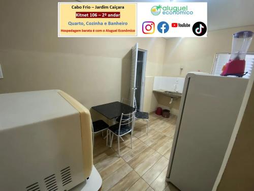 a room with a microwave and a table and a refrigerator at Cabo Frio - Jardim Caiçara - Aluguel Econômico in Cabo Frio