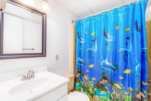 a bathroom with a blue shower curtain with an aquarium at Barefoot Country 303 in Ocean City