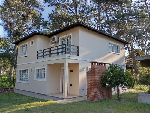 a large white house with a roof at Departamentos Ojos del Alma in Valeria del Mar