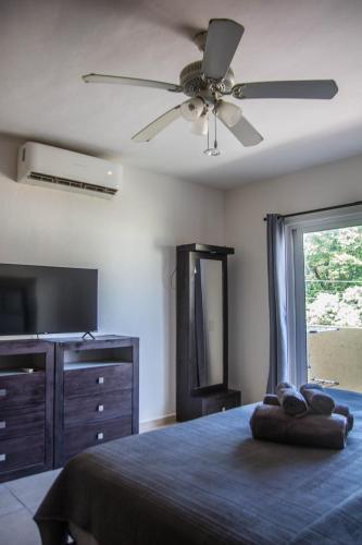 a bedroom with a ceiling fan and a bed and a dresser at Creuza de Mä in Playa del Carmen